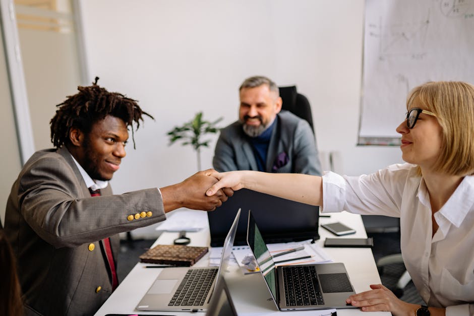 Professional colleagues shaking hands during a successful corporate meeting, showcasing teamwork and cooperation.
